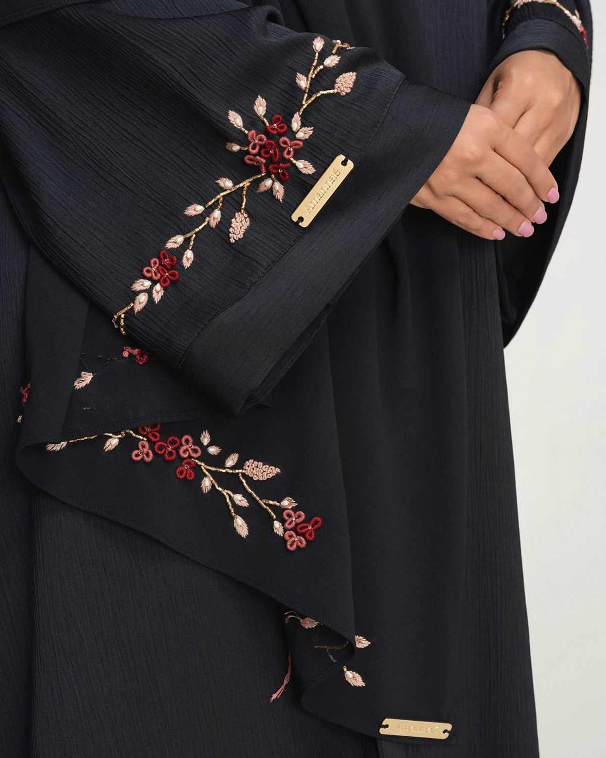 Burgundy and blush floral vines hand-embroidered on the black Oud abaya sleeve